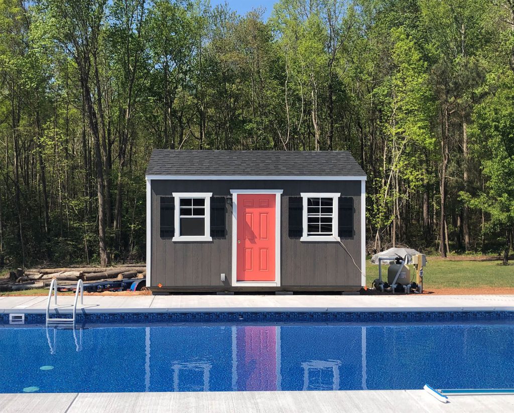 Utility-style pool shed near a swimming pool provides convenient storage for equipment, chemicals, and accessories while keeping the backyard organized. Pool sheds enhance functionality and reduce clutter, creating a cleaner and more enjoyable outdoor space.