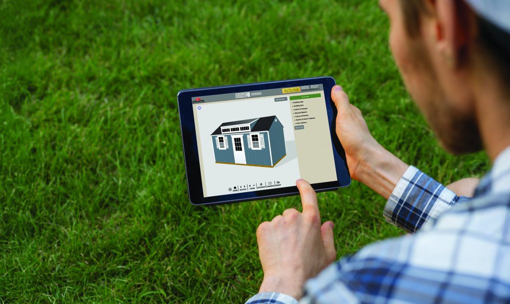 Person using a 3D shed design tool on a tablet to customize a backyard building and view real-time pricing. Demonstrates how buyers can estimate shed costs and personalize features before purchasing.