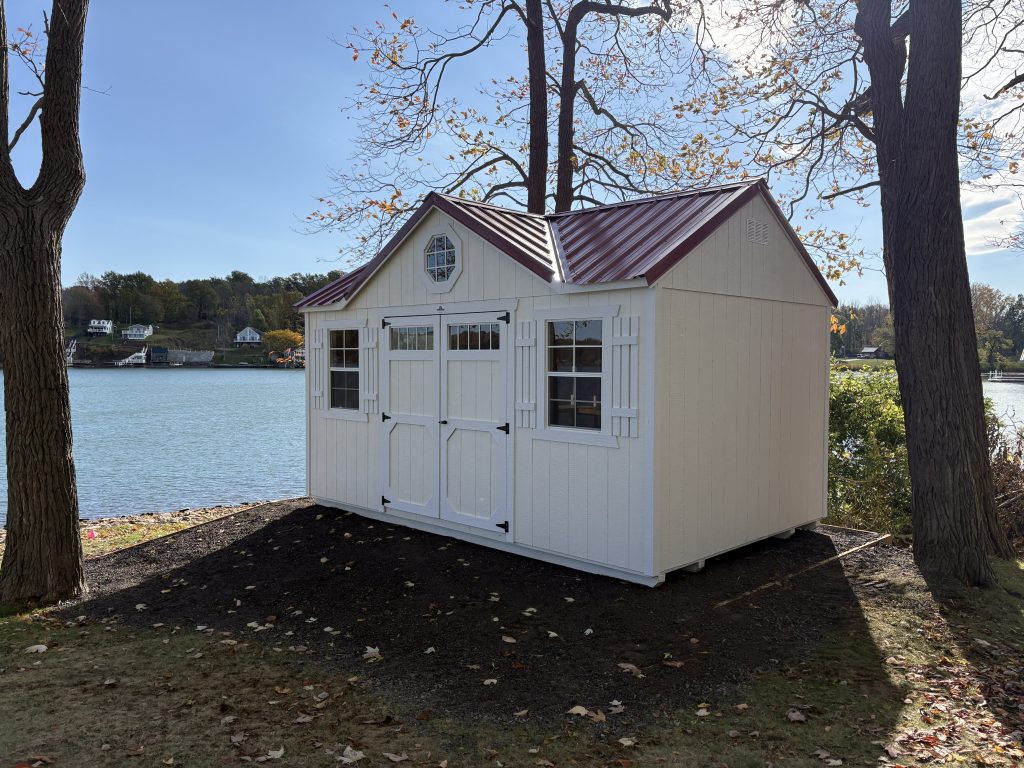 White utility shed with gable dormer package, illustrating how add-on upgrades enhance both appearance and shed price. A clear example of how package options transform a basic shed into a more functional and visually appealing structure.