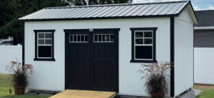 Modern white utility shed with black trim and double doors, showcasing a popular backyard storage shed style and base pricing starting point. Ideal example of a standard shed size and design that influences overall shed cost in 2026 pricing guide.